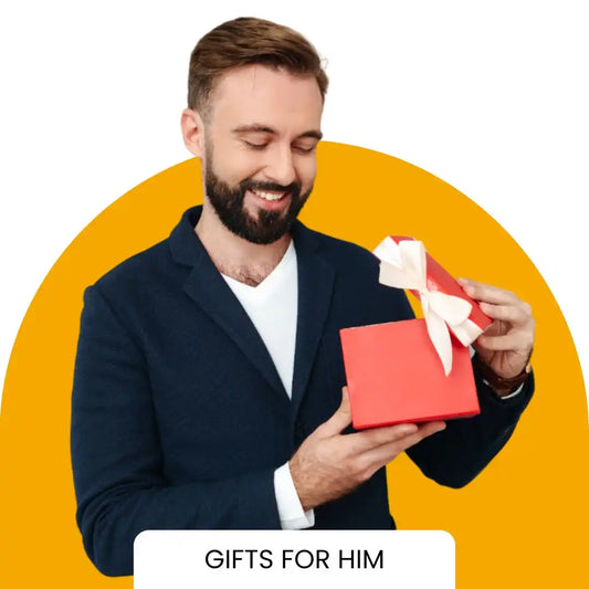 Bearded man in a navy blazer opening a red gift box against a yellow background.