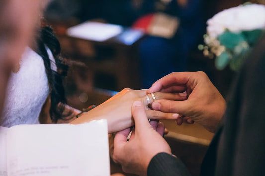 Wedding ring being placed on a finger during a ceremony.
